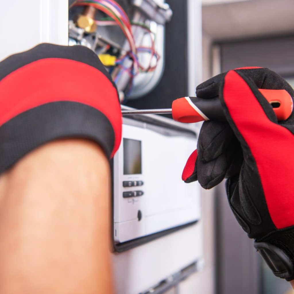 hands working on repairs for HVAC unit